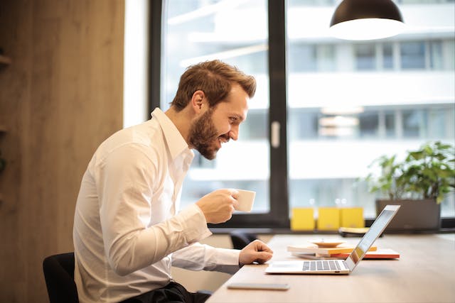 A person on a laptop smiling.