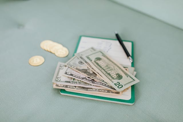 A clipboard with some American bills on top of it.