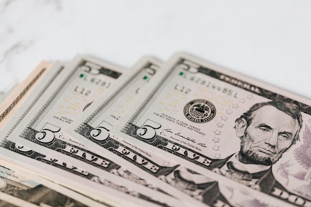 A selection of American five dollar bills on a table.